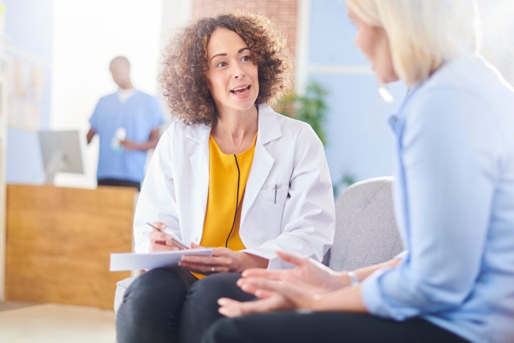 woman sitting with female doctor going over the risks of mixing alcohol and medication