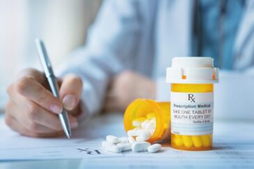 doctor writing on a form with a bottle of pills sitting next to her going over Trazodone vs Benzodiazepines: What's The Difference